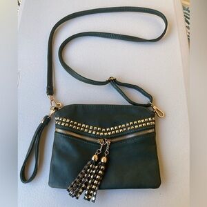 Dark green convertible bag with gold studded hardware and fringe zipper details